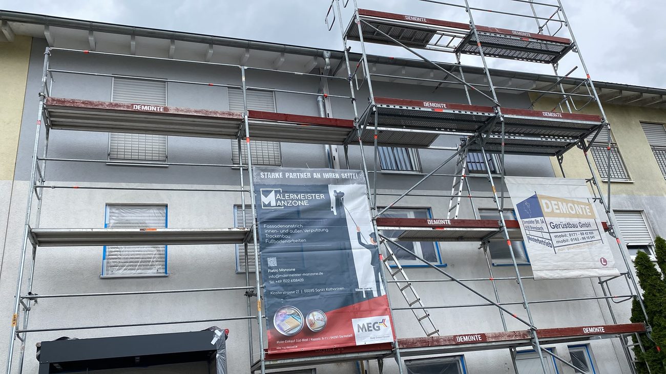 Gerüst an einer Hausfassade mit Malermeister-Manzone-Banner
